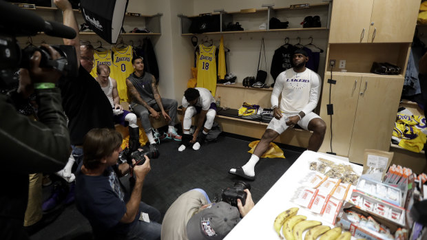 LeBron James sits in the Lakers' locker room with the press before the NBA pre-season game against Denver.
