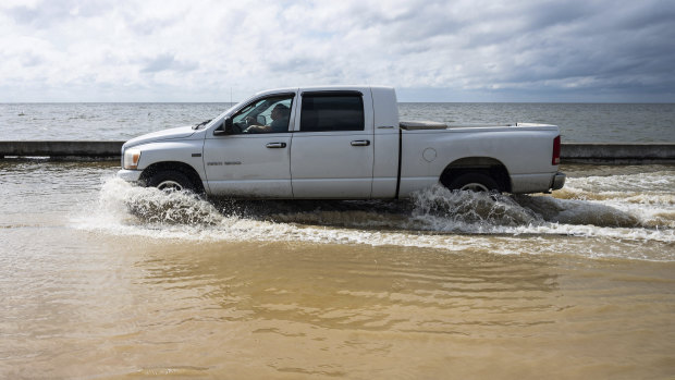 A truck drives through seawater as Beach Boulevard floods in Waveland, Mississippi.