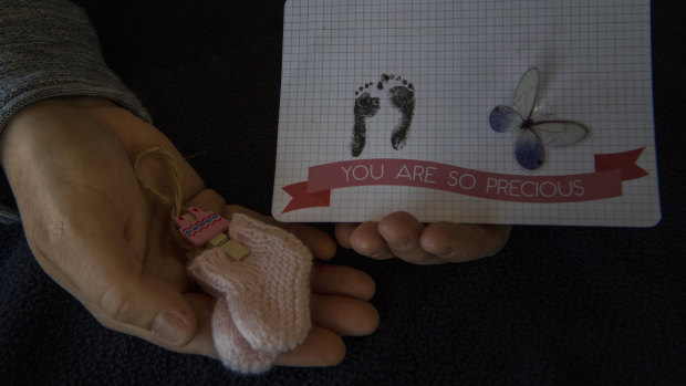 Ali holds mementos of her daughter who had developed severe abnormalities in utero.  