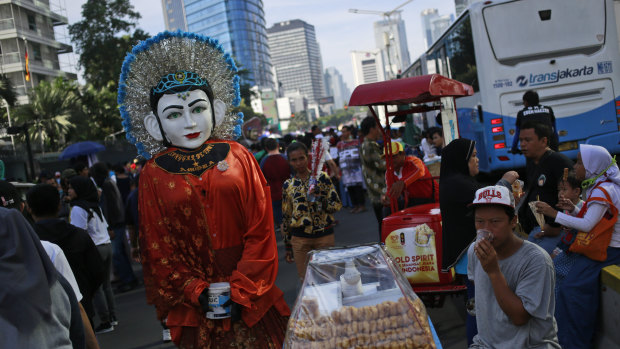 A street busker in a traditional giant puppet, called ondel-ondel, in Jakarta. The world's third-largest democracy is gearing up to hold its legislative and presidential elections.