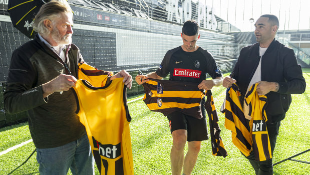 Pendlebury signs Hawks jumpers for Tuck and Burgoyne.