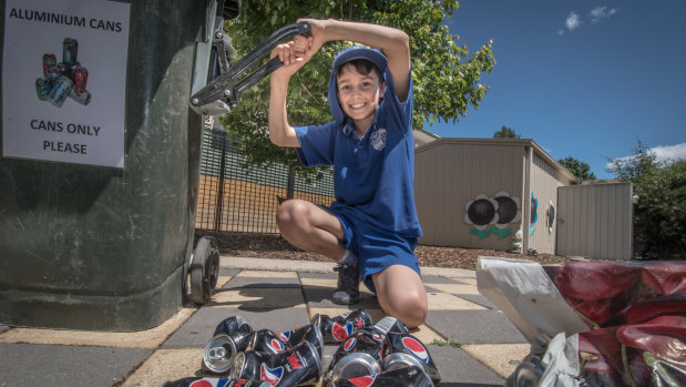 Eco-detective at Garran Primary Rex Martin, 10, crushes collected cans as part of the school's extensive recycling program.