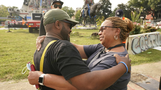 Devon Henry, owner of the construction company that removed the statue, hugs his mother, Freda Thornton, after the removal of the statue from Monument Avenue, Richmond, Virginia. 