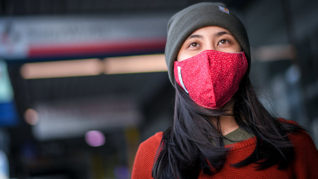 Nhi Tran wears a mask in Melbourne manufactured by SisterWorks, a small social enterprise manufacturing masks in Richmond. "It's a simple gesture to protect the community and our relatives," she says. 