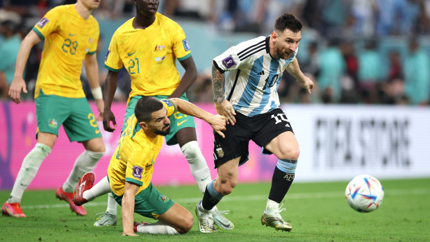 Lionel Messi battles for possession with Aziz Behich.