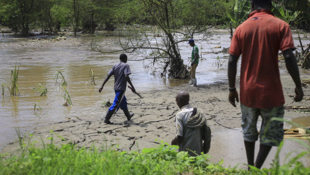 Residents gather after flooding on the the River Hululu, which joins the Rver Lubiriha, near Beni, eastern Congo.