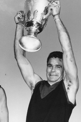 Ron Barassi holds the 1964 premiership cup aloft after the Demons triumph over Collingwood.