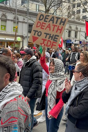 A woman holds a sign calling for death to the Israel Defence Forces. 
