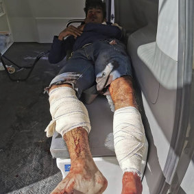 A man injured in an air strike that hit a biscuit factory waits in an ambulance in the capital, Tripoli.