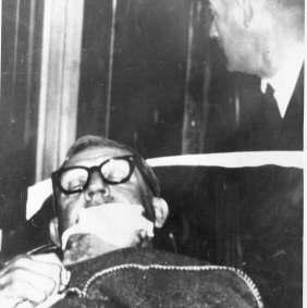 His facial injuries covered by a bandage, Calwell is wheeled on a stretcher into Sydney’s Royal North Shore hospital after he was shot on the night of June 21, 1966. 