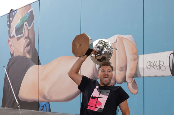 Dylan Alcott holds the men's quad wheelchair trophy aloft while in Richmond on Sunday for the unveiling of a giant mural in his image.
