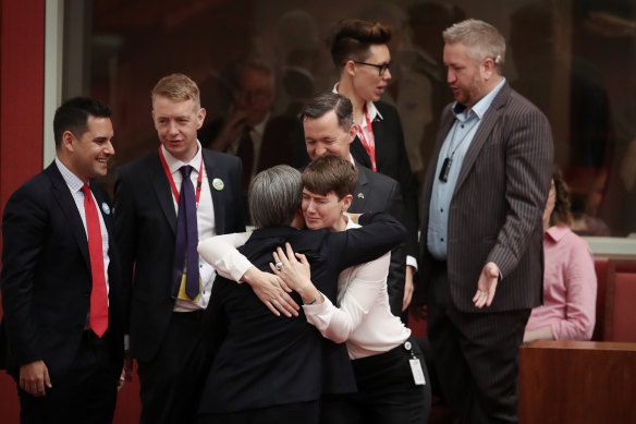 Anna Brown, in white top, hugs Penny Wong in the Senate chamber on November 16, 2017.