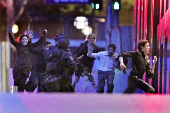 Hostages flee after police storm the Lindt cafe in the early hours of December 16, 2014.