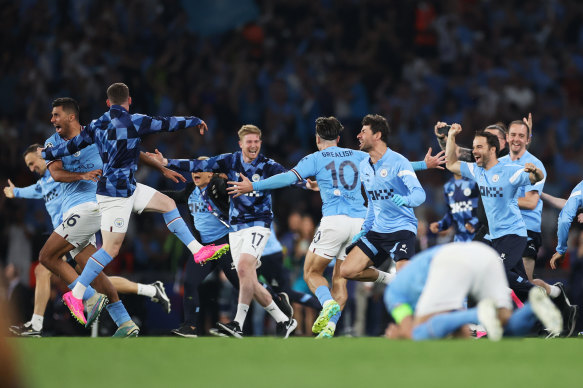 Manchester City players and staff celebrate after the team’s victory.