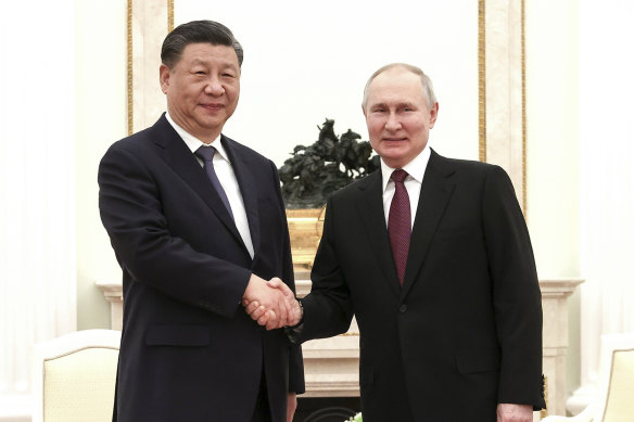 Vladimir Putin and Xi Jinping shake hands before their meeting.