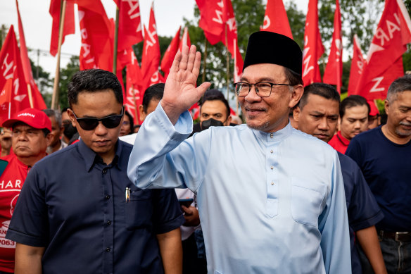 Anwar Ibrahim greets supporters as he arrives to submit his nomination in the seat of Tambun, in Perak state, on Saturday.