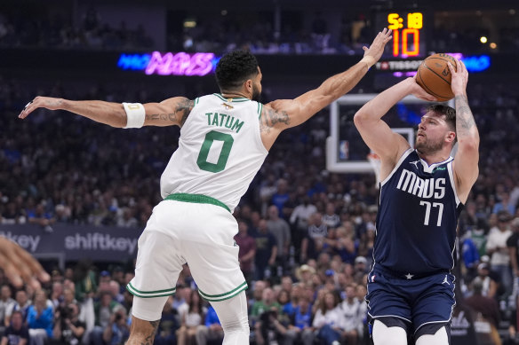 Dallas Mavericks guard Luka Doncic (77) shoots against Boston Celtics forward Jayson Tatum (0).