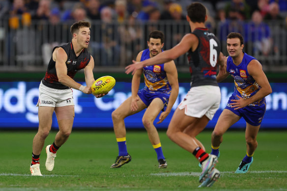 Zach Merrett of the Bombers handballs.