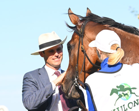 James Cummings gives In Secret a pat after winning the Newmarket handicap at Flemington.