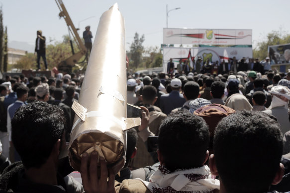 A Yemeni in Sanaa protester lifts a mock missile while participating in a protest staged against the US-led sustained airstrikes on Yemen.