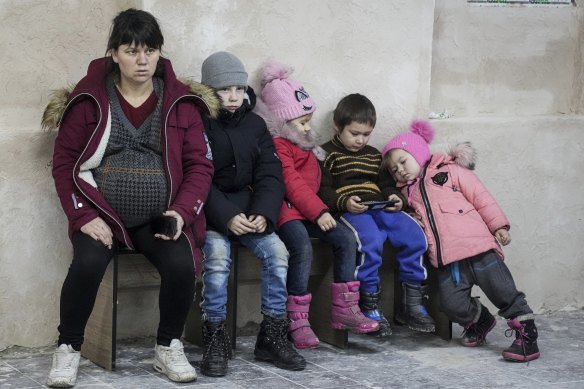 A pregnant woman sits with children on a bench in a sports centre in Mariupol, Ukraine, that became an improvised bomb shelter when Russia invaded the country.
