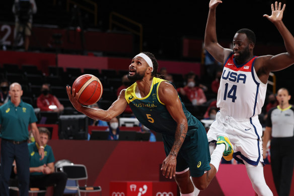 Draymond Green fouls Australia’s Patty Mills.