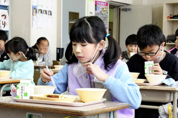 Children remove their masks to eat lunch at Uramachi Elementary School in Aomori, Japan.