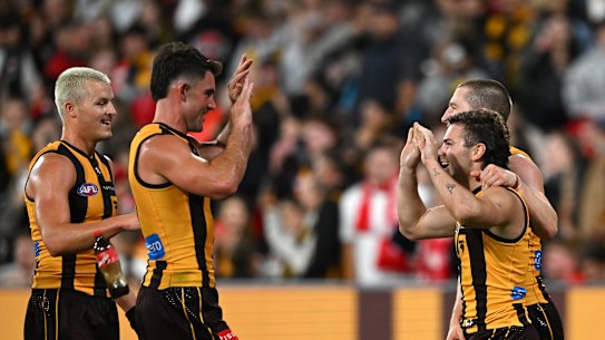 The Coke bottle passes by the waist of Hawthorn’s Jack Ginnivan (left).
