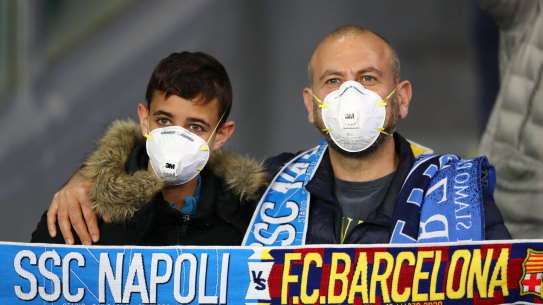 Fans were face masks at the Champions League match between Napoli and Barcelona in Italy.
