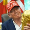 President Donald Trump holds the FIFA World Cup Winners Trophy during an announcement in the Oval Office of the White House on Friday.