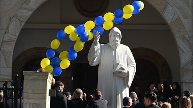 Balloons are released during the funeral of John Versace on Friday.
