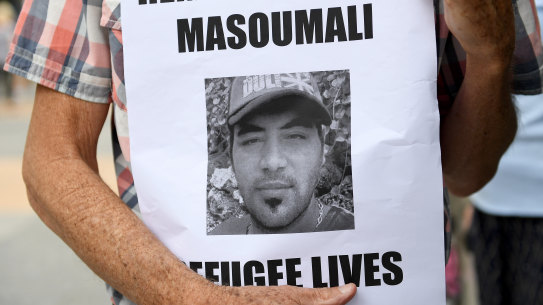 A photograph of Omid Masoumali is held outside the Brisbane Magistrates Court in Brisbane.