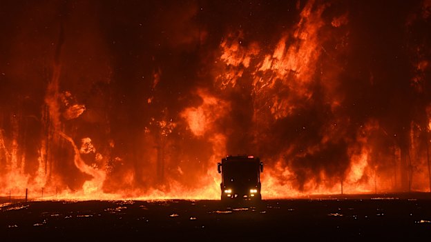 Firefighters overwhelmed by flames at a bushfire in Orangeville, west of Campbelltown.