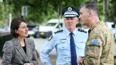 Premier Gladys Berejiklian with NSW Police Commissioner Mick Fuller and Brigadier Mick Garraway at the Victorian border checkpoint yesterday.