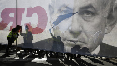 Israelis demonstrate in Tel Aviv next to a banner showing Prime Minister Benjamin Netanyahu during a protest against the rising cost of living.