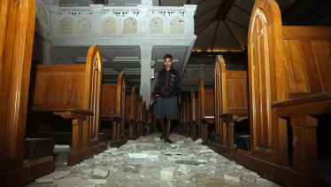 A man walks inside a church where debris has fallen after the earthquake in Bali.