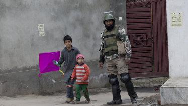 Kashmiri children walk past an Indian paramilitary soldier in Srinagar, Indian-controlled Kashmir.