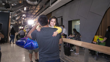 Amayra, 2, greets her dad, Vikram, after arriving on first international passenger flight to Melbourne Airport since July.