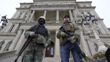 Armed men stand on the steps at the State Capitol after a rally in support of President Donald Trump in Lansing, Michigan, on the same day as the US Capitol in Washington was attacked.
