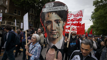 A protester holds a sign featuring an image of Canadian Prime Minister Justin Trudeau while marching against the G7 summit in Quebec.