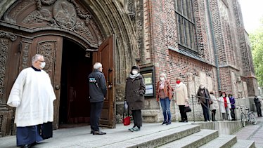 People arrive at Munich's Frauenkirche 'Cathedral of Our Lady' on May 4, the first day churches were allowed to hold services again in Bavaria. 
