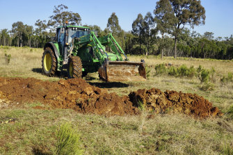 A rare photo of camera shy Nigel McGrath at the wheel of his tractor helping excavate the site near Gulgong where he found fossils. 