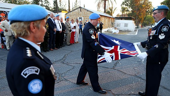 Australian U.N police officer fold the Australian flag during a flag-lowering ceremony to ended Australia's peacekeeping contribution in Cyprus in Nicosia in 2017.