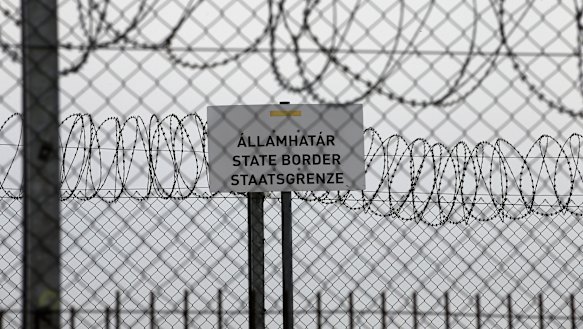 A sign reading: “State Border” is attached to a fence at Hungary’s border with Serbia near the village Asotthalom, Hungary.