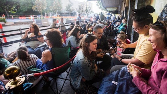 Brendan Wang, in yellow, and friend Chi Han Yeo, with his ukulele, in the queue with two new friends.