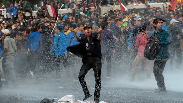 Student protesters shout slogans agaisnt the changes to the penal code during clashes outside Parliament in Jakarta, Indonesia, on Tuesday.