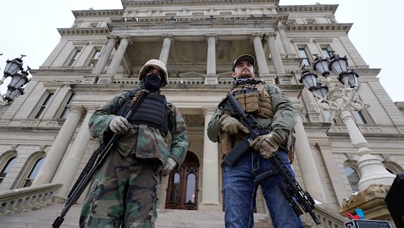 Armed men stand on the steps at the State Capitol after a rally in support of President Donald Trump in Lansing, Michigan, on the same day as the US Capitol in Washington was attacked.