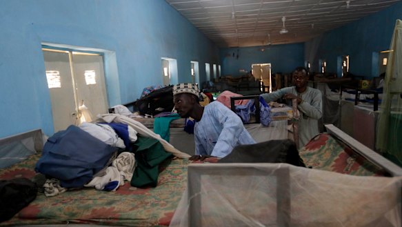 People inspect belongings of missing Government Science Secondary School student at their hostel in Kankara, Nigeria.