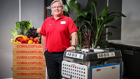 Coles chief Steven Cain with one of the 'daleks' that will pick online grocery orders. 