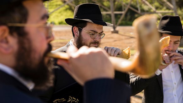 Members of the Jewish community blow on shofars during the ceremony at Rookwood Cemetery.